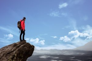 Man standing on cliff overlooking a valley