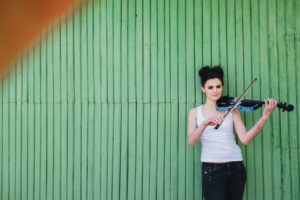 Woman happily playing the violin.
