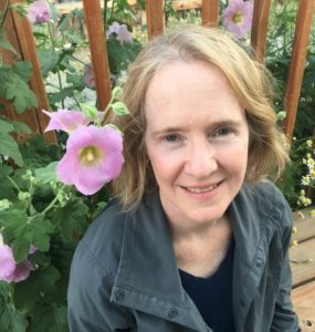 Terry Kerler sitting in garden with pink flowers
