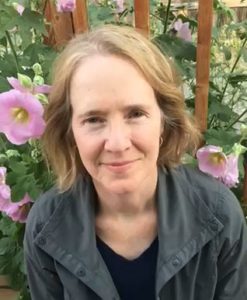 Terry Kerler, LPC sitting in garden with pink flowers